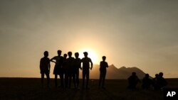 Young men who say they deserted the Afghan military and fled to Turkey through Iran stand in the countryside in Tatvan, in Bitlis Province in eastern Turkey, Aug. 17, 2021.