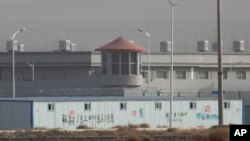 FILE.- A guard tower and barbed wire fences are seen around a facility in the Kunshan Industrial Park in Artux in western China's Xinjiang region, Dec. 3, 2018.