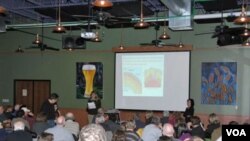 Panitia penyelenggara Cynthia Wichelman memperkenalkan pembicara pada acara 'Science on Tap' di restoran Schlafly Bottleworks. Kegiatan Science Cafe semacam ini mendekatkan para ilmuwan dan masyarakat untuk membumikan sains.