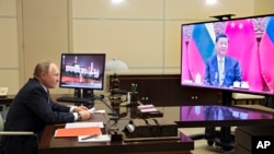 Russian President Vladimir Putin talks with Chinese President Xi Jinping via videoconference at the Novo-Ogaryovo residence outside Moscow, Russia, Dec. 15, 2021.