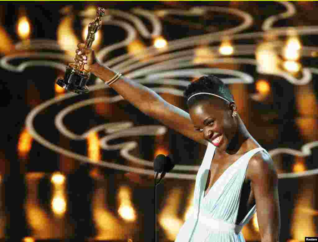 Lupita Nyong'o, aktris pendukung terbaik untuk perannya dalam "12 Years a Slave", menerima penghargaan di panggung Academy Awards ke-86 di Hollywood, California (2/3). (Reuters/Lucy Nicholson)