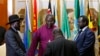 FILE - South Sudan's rebel leader Riek Machar, right, and South Sudan's President Salva Kiir hold a priest's hands before signing an earlier peace agreement in Addis Ababa, May 9, 2014.
