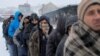 Migranti čekaju u redu kako bi primili besplatan tanjir hrane, na snegu, ispred napušenog skladišta Carine u Beogradu, Srbija, 20. januara 2017. (REUTERS/Marko Djurica - RTSW2DA)
