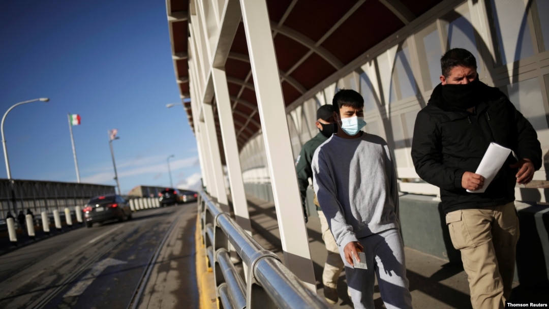 Un migrante es escoltado por un agente del Instituto Nacional de Migración (INM) de México, luego de ser deportado de Estados Unidos, en Ciudad Juárez.