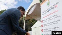 FILE - A man disinfects his hands against the spread of coronavirus disease (COVID-19) at State House in Harare, Zimbabwe, March 19, 2020. 