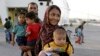 A family from Afghanistan arrives from the northeastern Greek island of Lesbos to the Athens' port of Piraeus on Monday, Sept. 7, 2015.