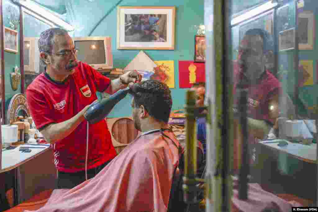 A Cairo barber shop is busy as men line up to get their hair cut as they prepare to celebrate Eid.