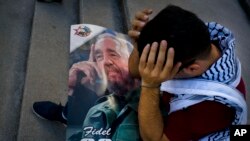 Seorang mahasiswa kedokteran Palestina, Adham Motawi, membawa gambar Fidel Castro, berduka atas kematiannya dalam sebuah acara memorial di Havana, Kuba, sehari setelah kematiannya (26/11). (AP/Ramon Espinosa)