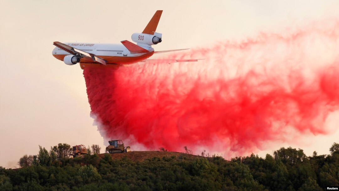 A DC-10 air tanker drops fire retardant along the crest of a hill to protect the two bulldozers below that were cutting fire lines at the River Fire (Mendocino Complex) near Lakeport, Calif., Aug. 2, 2018.