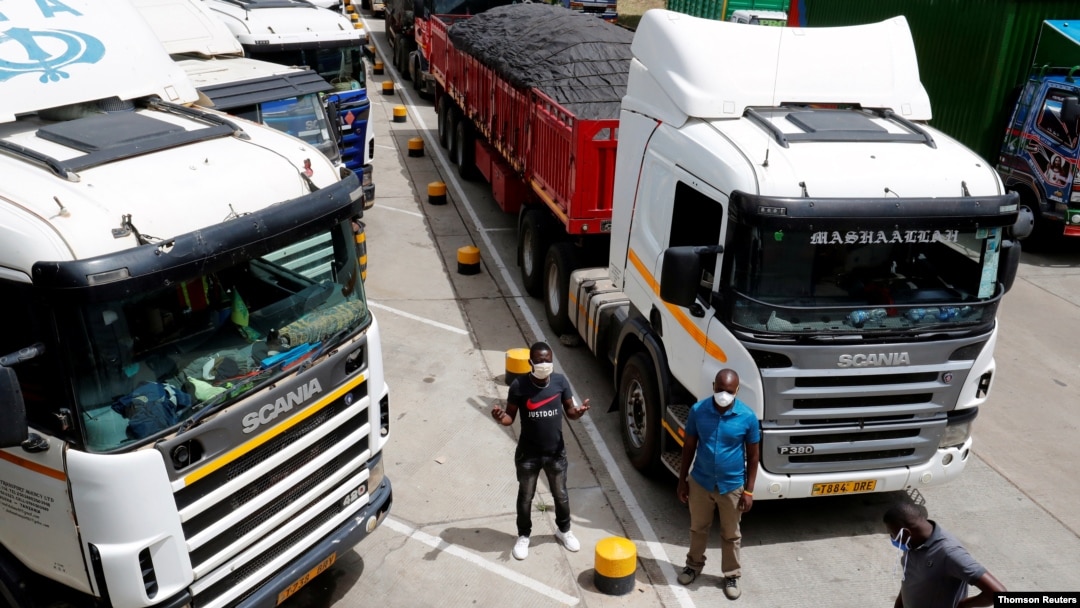 Truck drivers are seen near their parked vehicles as they await test results, amid the spread of the COVID-19 outbreak at the Namanga one-stop border crossing point between Kenya and Tanzania in Namanga, Kenya, May 12, 2020. 