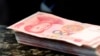 FILE - Chinese 100 yuan banknotes are seen on a counter of a branch of a commercial bank in Beijing, China, March 30, 2016. 