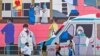 Pedestrians walk past a wall mural promoting awareness on using face masks, in Bengaluru on January 6, 2025,