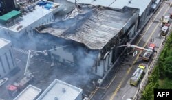 Petugas pemadam kebakaran tengah memadamkan api di pabrik baterai lithium di Hwaseong, Korea Selatan, 24 Juni 2024. (AFP)