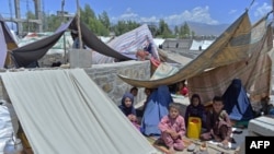 Afghan families who have been displaced due to fighting between Taliban and Afghan forces, take temporary shelter at a market in Mihtarlam, the capital of Laghman Province on May 24, 2021.