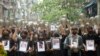 Pengunjuk rasa anti-kudeta memegang foto orang-orang yang tewas dalam protes terhadap militer menawarkan doa untuk mereka, di Yangon, Myanmar, Senin, 5 April 2021. (Foto: AP)