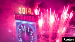 Fireworks explode past the Times Square Ball after it dropped to signal the start of the new year in Times Square, Midtown, New York January 1, 2014. REUTERS/Adrees Latif (UNITED STATES - Tags: SOCIETY) - RTX16YQG