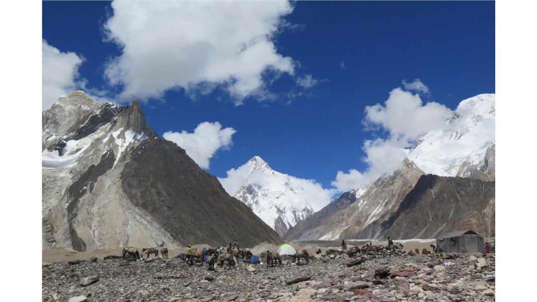 FILE - Porters set up tents at the Concordia camping site in front of K2 summit in the Karakoram range of Pakistan's northern Gilgit region, Aug. 14, 2019.
