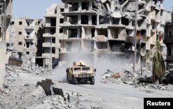 An armoured vehicle of the Syrian Democratic Forces is seen along a road at the frontline in Raqqa, Syria October 8, 2017.