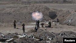 Members of the Iraqi army and Shi'ite fighters launch a mortar toward Islamic State militants on the outskirts of the city of Falluja, Iraq May 19, 2015.