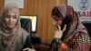 Seorang pengacara Pakistan Shandana Naeem, kanan, sedang menelepon bersama rekannya Nayab Hassan di kantor mereka di Peshawar, 28 Maret 2017. (Foto: AP)