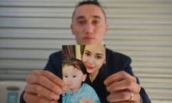 Australian Uighur Sadam Abdusalam holds up a photo of his wife Nadila and their toddler son Lutfi, whom he has never met. He is trying to get them released from China.