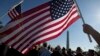 Anggota Marinir AS Terri Shreiner mengibarkan bendera AS dalam pawai di Washington Memorial, menuntut penghentian penutupan sebagian kegiatan pemerintah, di Washington, 15 Oktober 2013.