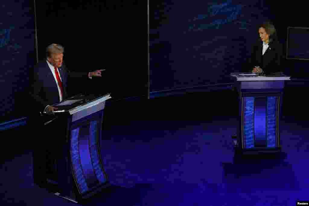 Republican presidential nominee, former U.S. President Donald Trump speaks as Democratic presidential nominee, Vice President Kamala Harris listens as they attend a presidential debate hosted by ABC in Philadelphia, Pennsylvania, Sept. 10, 2024. 