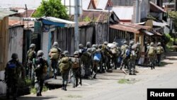 FILE - Philippine Marines advance their positions as more soldiers reinforce to fight the Maute group in Marawi City in southern Philippines May 29, 2017.