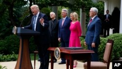 Presiden Donald Trump menyampaikan pidatonya di Rose Garden (Taman Mawar) Gedung Putih, Washington, sebelum penandatanganan inpres yang bertujuan untuk mengurangi peraturan IRS yang membatasi aktivitas politik untuk gereja-gereja, 4 Mei 2017. Didampingi oleh (dua dari kiri ke kanan:) Kardinal Donald Wuerl, Uskup Agung Washington, Pastor Jack Graham, Paula White, pastur senior New Destiny Christian Center di Apopka, Florida dan Wapres Mike Pence. (AP Photo/Evan Vucci)