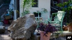 A large rock sits in a resident's backyard after it fell during a magnitude 5.9 earthquake in Guanica, Puerto Rico, Jan. 11, 2020. The morning quake damaged the island’s southern coast.