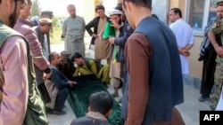 Relatives and others gather around the coffin of a soldier who died in heavy fighting between Afghan security and Taliban forces, outside a hospital in Takhar province, Oct. 21, 2020. A dozen children were killed in an airstrike a day later.