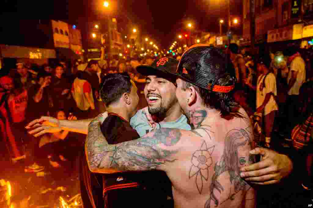 Fans embrace in the Mission District after the San Francisco Giants beat the Kansas City Royals to win the World Series, San Francisco, Oct. 29, 2014.