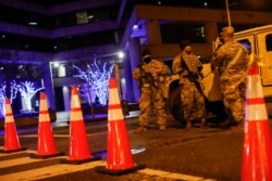 FILE - National Guard personnel and police secure a street near the Capitol, Jan. 17, 2021.