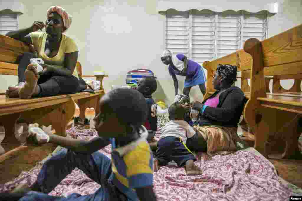Families gather at a shelter in a local church during the evening before the arrival of Hurricane Irma in Las Terrenas, Dominican Republic, Sept. 6, 2017.