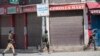 Polisi berlarian di dekat lokasi baku tembak di Sopore, 55 kilometer utara Srinagar, Kashmir yang dikuasai India, Sabtu, 12 Juni 2021. (AP/Mukhtar Khan)