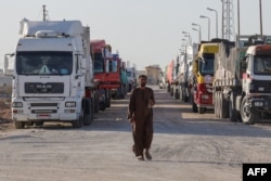 Truk berisi bantuan kemanusiaan menunggu untuk memasuki Rafah sisi Palestina di perbatasan Mesir dengan Jalur Gaza pada 11 Desember 2023. (Foto: AFP)