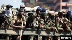 Members of the military gesture to the photographer as they patrol the streets of the capital Harare, Zimbabwe, Aug. 2, 2018.