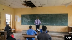 FILE - A teacher wearing a face shield teaches a class at the Technical High School of Nkol-Bisson in Yaoundé, Cameroon, June 1, 2020. 