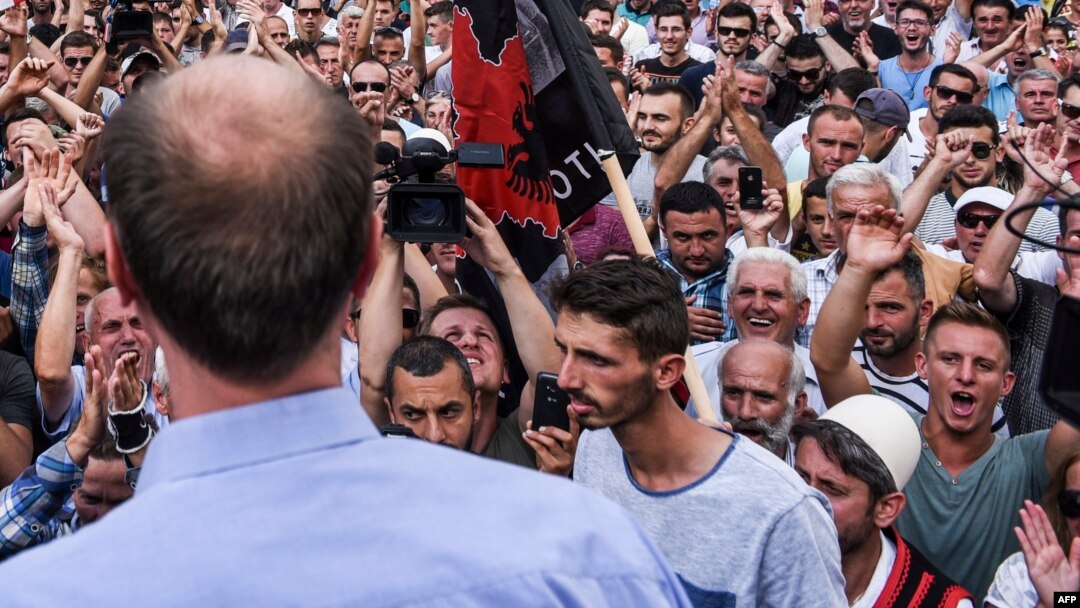 Kosovo's Albanians protest outside the parliament building in Pristina, Sept. 1, 2016. The protesters cheered as as the government withdrew a controversial draft law on a border demarcation agreement with Montenegro.