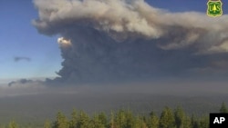 In this Tuesday, Aug. 17, 2021 file image from a U.S. Forest Service wildfire monitoring camera, plumes of smoke rise from the Caldor Fire in El Dorado County, Calif. (U.S. Forest Service/ALERTWildfire Network via AP, File)
