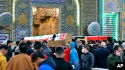Mourners carry flag-draped coffins of suicide bomb victims at the Imam Ali shrine in Najaf, Iraq, Thursday, Jan. 21, 2021. Iraq's military said twin suicide bombings at the Bab al-Sharqi commercial area in central Baghdad Thursday ripped through the…