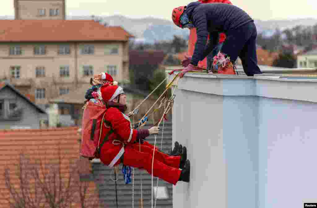 Volunteers dressed in Santa Claus costumes rappel from the roof of Children's Hospital Srebrnjak to bring gifts to the children, in Zagreb, Croatia.