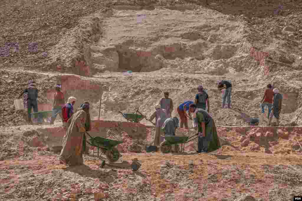 Egyptian excavation workers remove sand and debris during the project in Luxor, Egypt. (H. Elrasam/VOA)