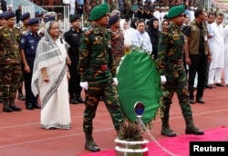 Bangladesh's Prime Minister Sheikh Hasina pays homage in front of the coffins of the victims who were killed in the attack on the Holey Artisan Bakery and the O'Kitchen Restaurant, during a memorial ceremony in Dhaka, July 4, 2016.