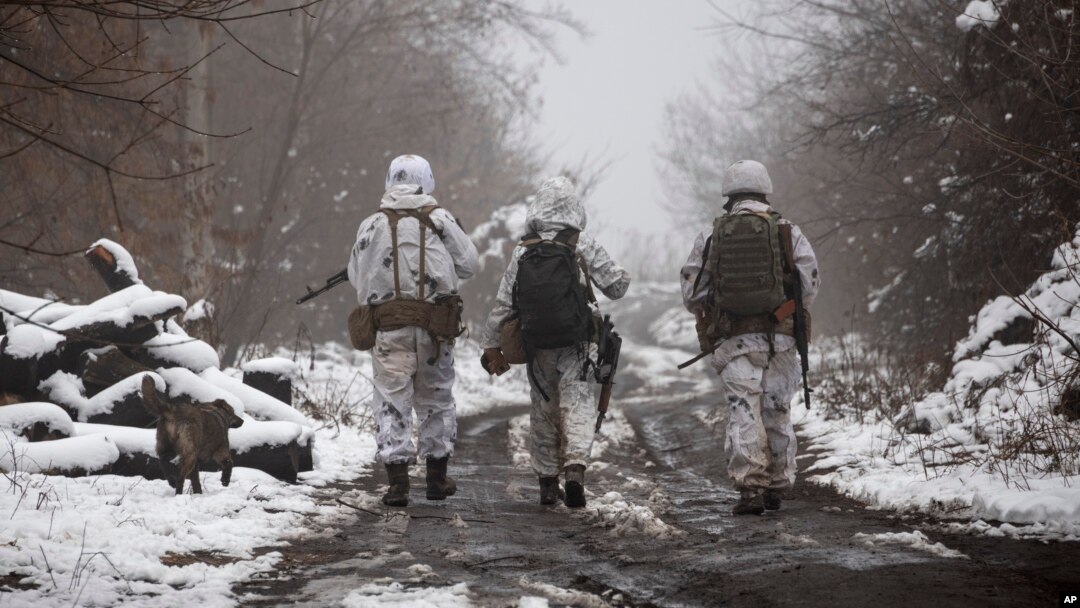 FILE - Ukrainian soldiers walks near the line of separation from Russia-backed rebels near Katerynivka, Donetsk region, Ukraine, Dec 7, 2021.
