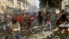 Protesting university students flee as police fire stun grenades outside Parliament in Cape Town, South Africa, Oct. 21, 2015.