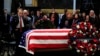 Mantan Senator Bob Dole memberi hormat di hadapan peti jenazah mantan presiden George H.W. Bush yang diselimuti bendera dan disemayamkan di Gedung Capitol di Washington, 4 Desember 2018.