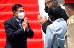 In this photo released by Indonesian Presidential Palace, Myanmar's Senior General Min Aung Hlaing, left, is greeted by an unidentified Indonesian official upon arrival at Soekarno-Hatta International Airport in Indonesia, April 24, 2021.
