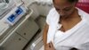 FILE - A mother performs Kangaroo care, or skin-to-skin contact, with her premature baby to give the baby the physical stimulation it needs.