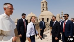 French President Emmanuel Macron (C) tours the Our Lady of the Hour Church with Dominican Father Olivier Poquillon (L) in Iraq's second city of Mosul, in the northern Nineveh province, on August 29, 2021. 